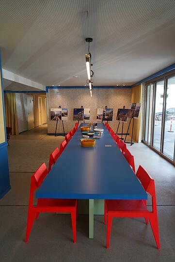 Schön knallig: Blaue Tafel mit roten Stühlen.