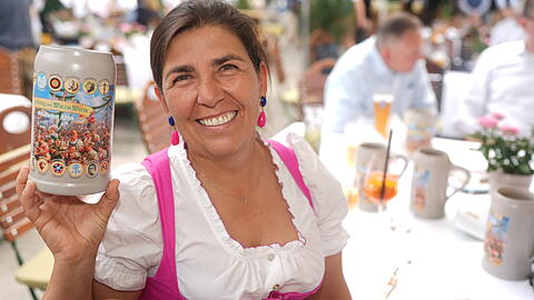Wiesnwirtin Katharina Inselkammer hat auf einem Flohmarkt eine alte Oktoberfest-Postkarte entdeckt und auf dem Krug verewigt.