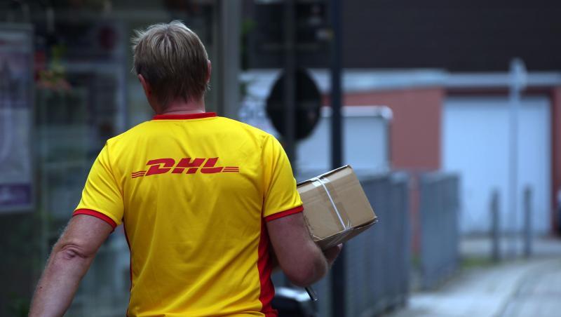 Ein DHL-Mitarbeiter liefert ein Paket aus. Ein DHL-Mitarbeiter liefert ein Paket aus.