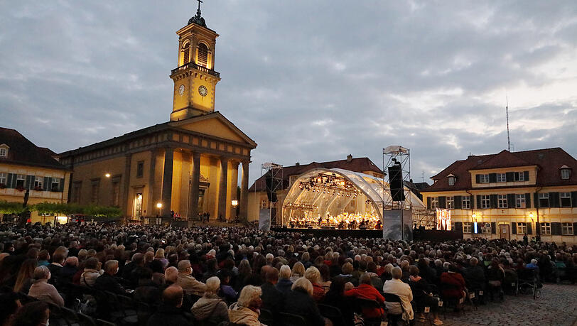 Trotz düsterer Wolken trocken: Der Karlsplatz in Ansbach mit der klassizistischen Ludwigskirche beim Konzert "Oper für alle" mit dem Bayerischen Staatsorchester.