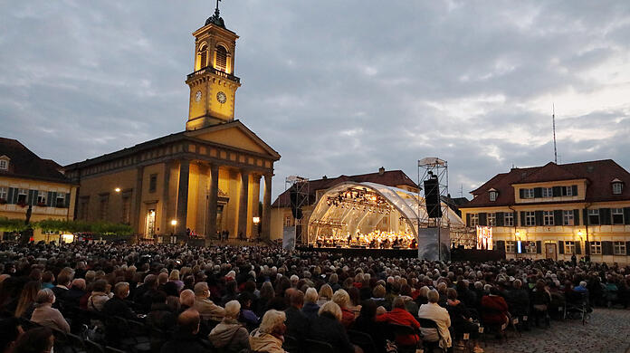 Trotz düsterer Wolken trocken: Der Karlsplatz in Ansbach mit der klassizistischen Ludwigskirche beim Konzert "Oper für alle" mit dem Bayerischen Staatsorchester.