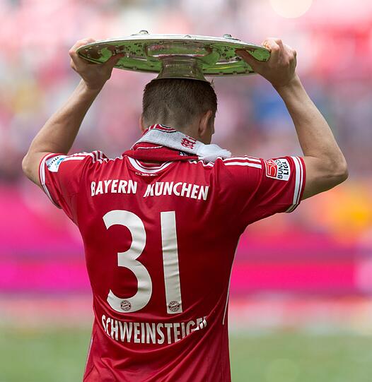 Schweinsteiger mti der Trophäe auf dem Kopf.