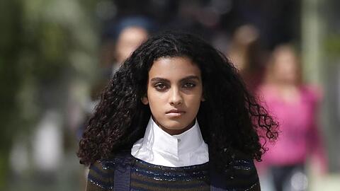 Ein Model trägt ein Outfit mit hohem weißem Vatermüörderkragen, der an Karl Lagerfeld erinnert.