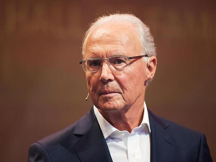 Franz Beckenbauer steht bei einer Veranstaltung auf einer Bühne. Foto: Ina Fassbender/dpa/Archivbild