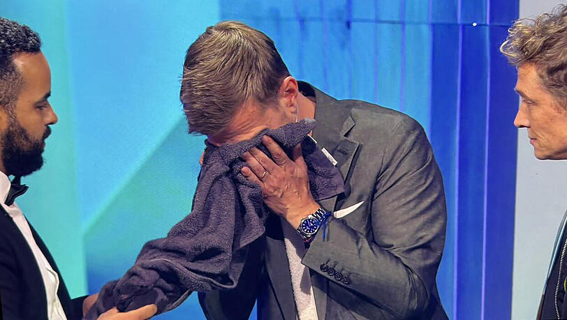 Mitarbeiter spülen Joko Winterscheidt die Augen aus und reichen ihm ein Handtuch Mitarbeiter spülen Joko Winterscheidt die Augen aus und reichen ihm ein Handtuch