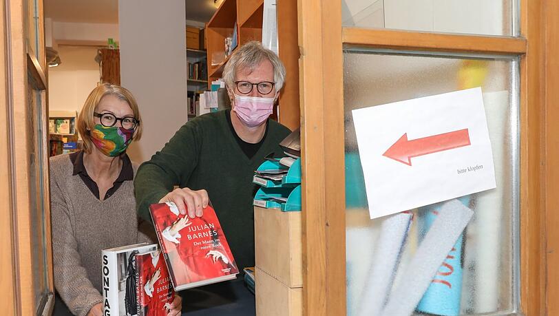 "Die Leute lesen wie wild": Christoph Selmeier (53) und Martina Nußberger (62) geben bestellte Bücher bei Colibris durchs Fenster im Hof aus.