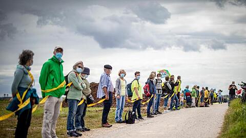 Umwelt- und Klimaschützer sowie Bewohner der angrenzenden Dörfer bilden am Rande des Braunkohletagebaus Garzweiler eine Menschenkette.