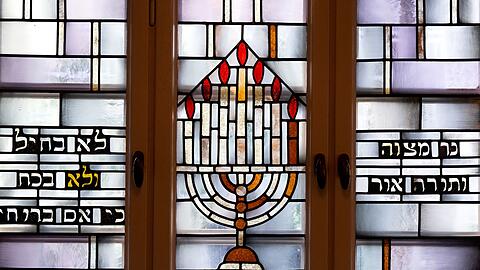 Die Bleiglasfenster zieren jüdische Ritualgegenstände, Symbole und Psalmen.