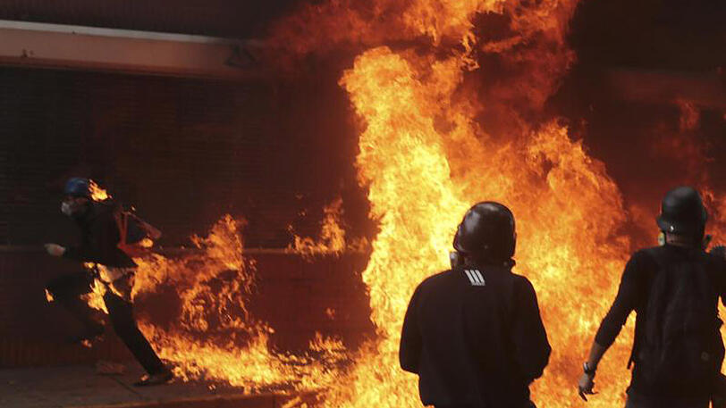 Ein Mann (L), der mit anderen Demonstranten ein Motorrad der Nationalgarde angezündet hat, versucht selbst brennend den Flammen zu entkommen.
