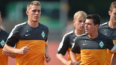 Werder Neuzugang Nils Petersen (l) läuft mit Zlatko Junuzovic beim Trainingsauftakt des Fußball-Bundesligisten Werder Bremen am Donnerstag (05.07.2012) auf dem Trainingsplatz in Bremen für einen Laktattest.