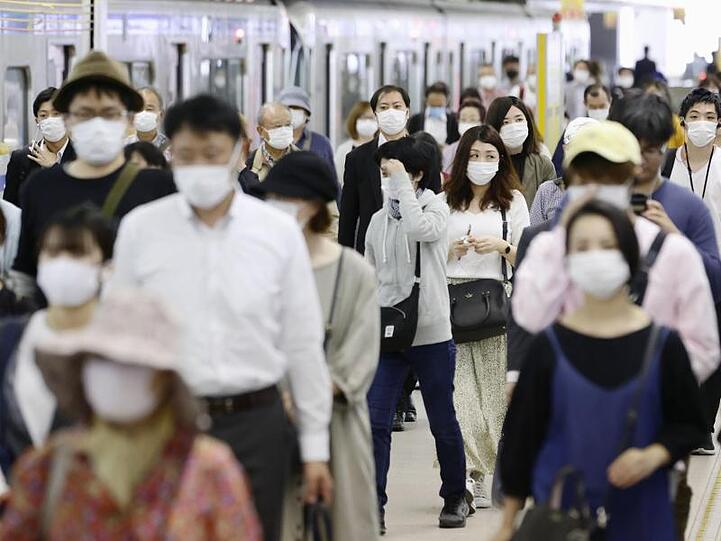 Pendler mit Gesichtsmasken am Bahnhof Fukuoka im Südwesten Japans.