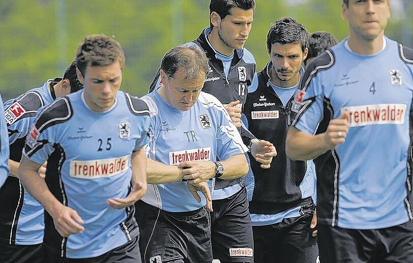 Ewald Lienen (Mitte) läuft inmitten seiner neuen Spieler bei der ersten Trainingseinheit bei den Löwen.