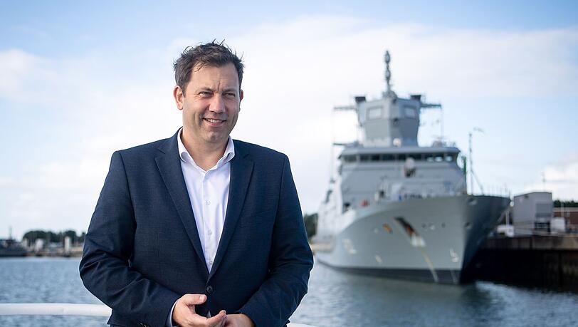 SPD-Chef Lars Klingbeil steht vor einem Schiff im Hafen vom Marinestützpunkt Wilhelmshaven.