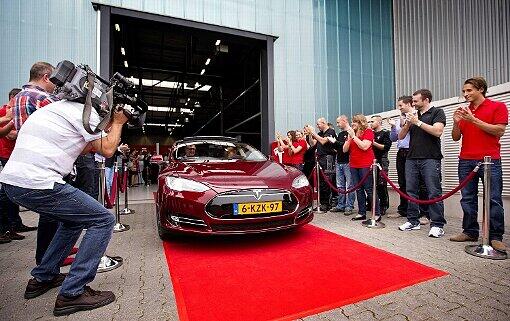 22. August 2013: Ein hier endmontiertes Modell des Tesla S verlässt die Halle im niederländischen Tilburg - auf dem roten Teppich im Blitzlichtgewitter.