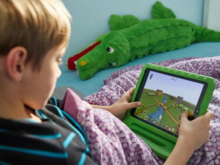Ein Junge spielt auf einem Ipad das Open-World-Computerspiel Minecraft. Foto: Georg Wendt/Archiv