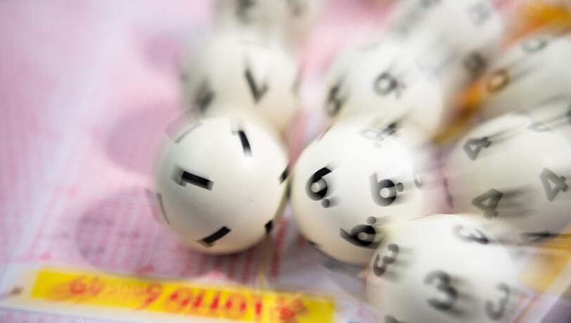Lotto-Kugeln liegen auf einem Lottoschein.