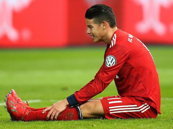 Münchens James Rodríguez sitzt mit ausgestreckten Beinen auf dem Rasen. Foto: Andreas Gora/Archivbild