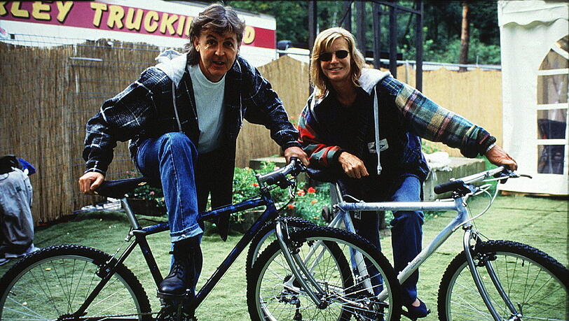 Paul und Linda McCartney mit Fahrrädern auf dem Weg zu einem Konzert auf der Berliner Waldbühne.