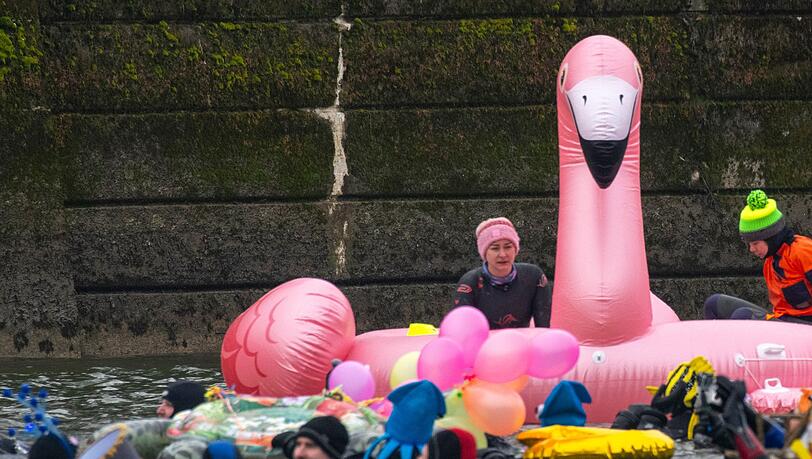 Teils bunt kost&uuml;miert schwimmen in und auf der eiskalten Donau Rettungsschwimmer.