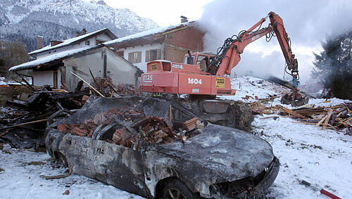 Ein demoliertes Auto liegt am Mittwoch (27.10.2010) vor einer Doppelhaushälfte in Krün (Oberbayern). Das Haus wurde in den frühen Morgenstunden durch eine Explosion zerstört. Ein demoliertes Auto liegt am Mittwoch (27.10.2010) vor einer Doppelhaushälfte in Krün (Oberbayern). Das Haus wurde in den frühen Morgenstunden durch eine Explosion zerstört.