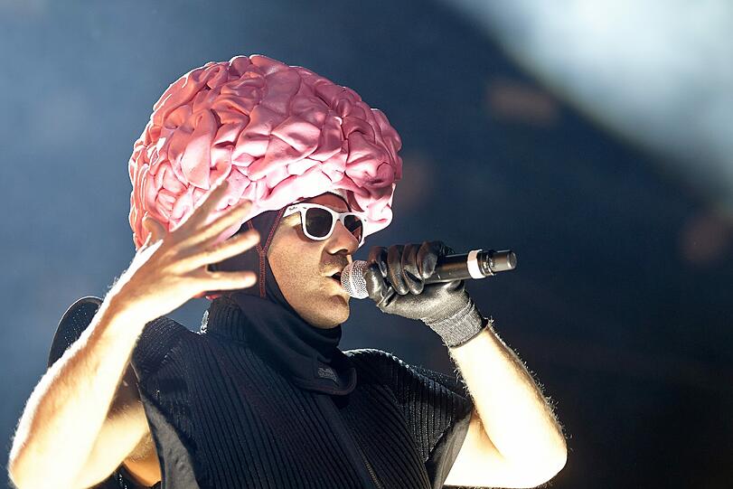 Ein Mitglied der deutschen Hip-Hop-Formation "Deichkind" steht mit einem Brain-Helm auf der Bühne beim "Rock am Ring"-Festival.