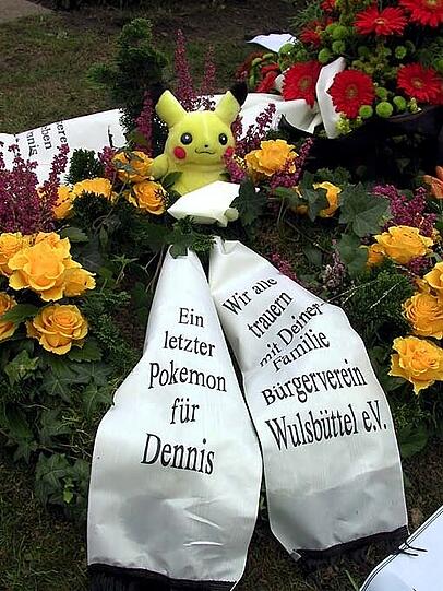 Eine Schleife mit einem Pokemon liegt auf dem Grab des neunjaehrigen Dennis Klein aus Osterholz-Scharmbeck.