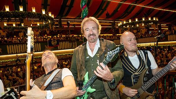 Die Bühne gehört ihm: Thomas Gottschalk (M.) spielt scherzhaft auf einer aufblasbaren Gitarre und rockt fröhlich mit der Band im Marstall.