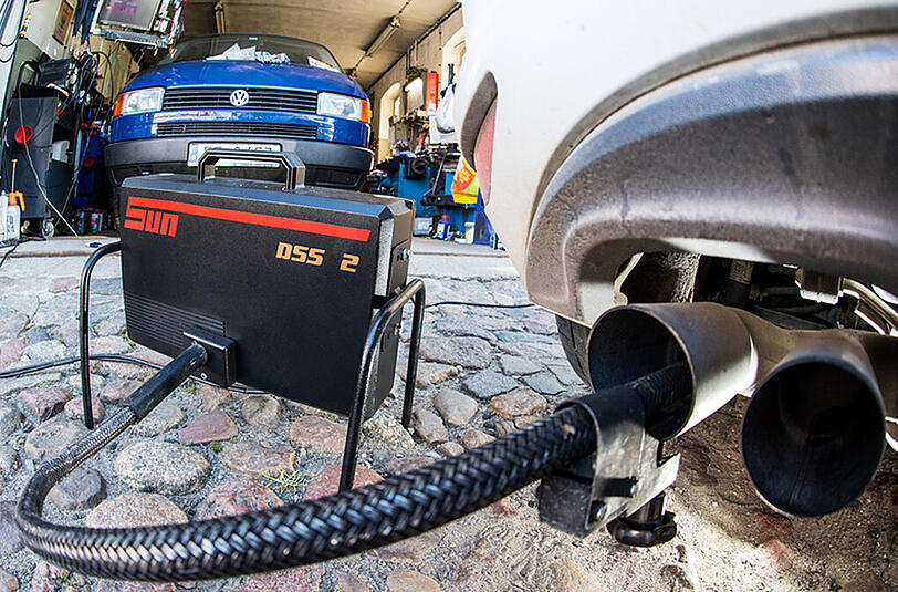 Ein Messschlauch eines Gerätes zur Abgasuntersuchung für Dieselmotoren steckt im Auspuffrohr eines VW Golf