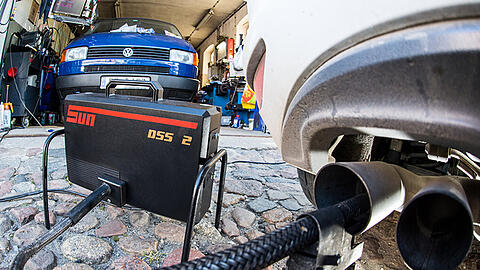 Ein Messschlauch eines Gerätes zur Abgasuntersuchung für Dieselmotoren steckt im Auspuffrohr eines VW Golf