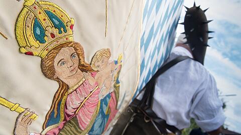 Als der historische "Schmied von Kochel" trägt ein Mann eine Marien-Fahne an Maria Himmelfahrt beim Großen Trachtenfestzug. Die Katholiken vor allem im Süden Bayerns begehen an diesem Samstag den traditionsreichen Feiertag Mariä Himmelfahrt.