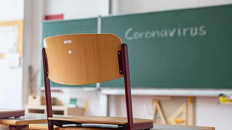 "Coronavirus" steht auf einer Tafel in einem leeren Klassenzimmer. Foto: Armin Weigel/dpa/Symbolbild