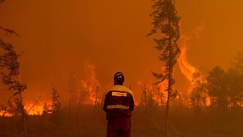 Ein Feuerwehrmann beobachtet westlich von Jakutsk in Russland einen Waldbrand.