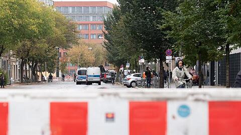 Absperrgitter und Einsatzfahrzeuge der Polizei stehen vor der geplanten Räumung der linken Bauwagensiedlung an der Köpenicker Straße.