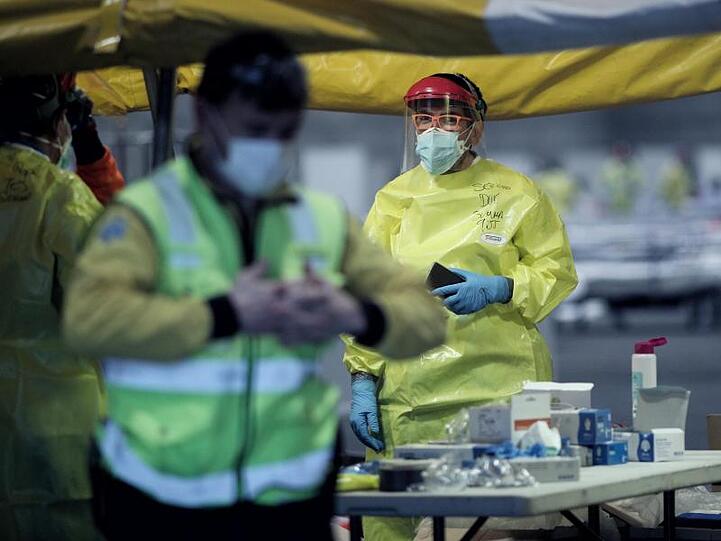 Gesundheitspersonal mit Schutzkleidung auf dem Gelände der Madrider Messe, wo Patienten mit leichten Symptomen behandelt werden.