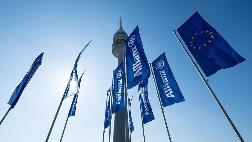 Fahnen des Versicherungskonzerns Allianz SE wehen vor der Olympiahalle.
