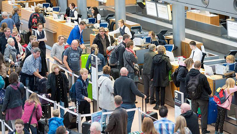 Fluggäste an den Check-In-Schaltern am Flughafen in Hamburg. Fluggäste an den Check-In-Schaltern am Flughafen in Hamburg.