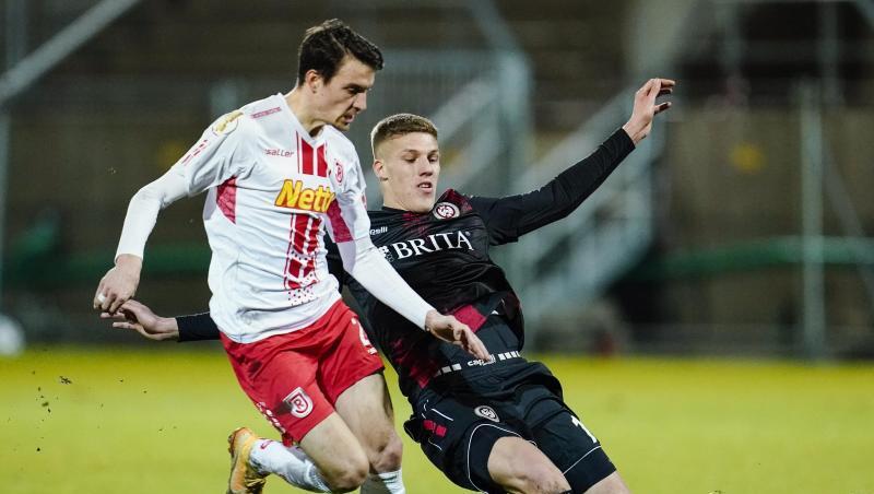 Regensburgs Sebastian Stolze (l) und Wiesbadens Jakov Medic kämpfen um den Ball.