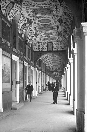 Eine Aufnahme um 1890: Der Blick in die hinter dem Bazargebäude beginnenden Hofgartenarkaden mit Kellnern, die den Gartenbetrieb des Cafés versorgen. Heute hingegen...