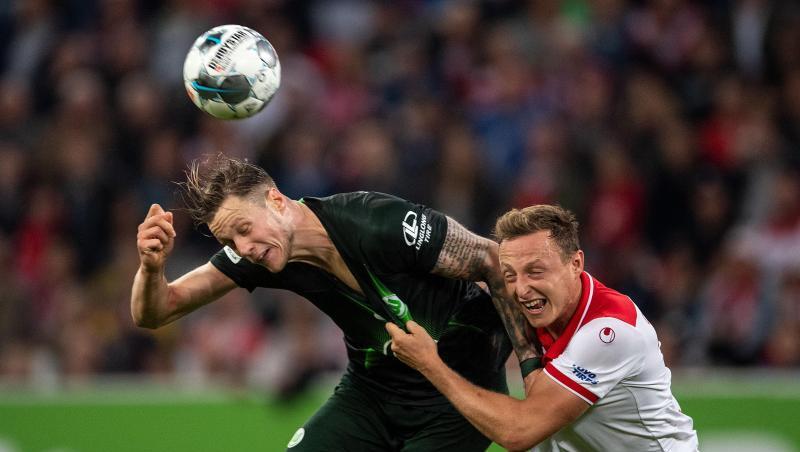 Düsseldorfs Robin Bormuth (r) und Wolfsburgs Wout Weghorst kämpfen um den Ball. Düsseldorfs Robin Bormuth (r) und Wolfsburgs Wout Weghorst kämpfen um den Ball.