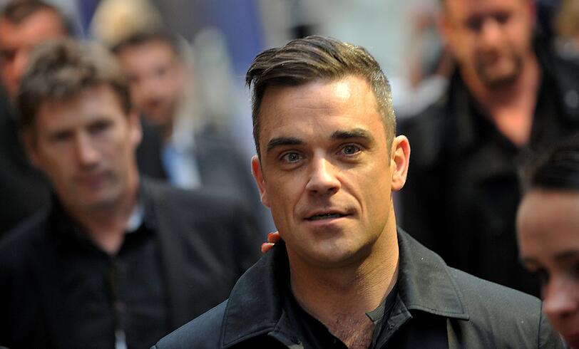 Weltstar im Fan-Gewusel: Robbie Williams verteilte Autogramme vor dem Mathäser-Kino.