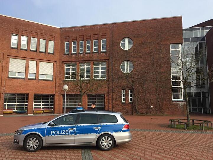 Ein Einsatzfahrzeug der Polizei steht während des Einsatzes vor der Eckener Schule in Flensburg.