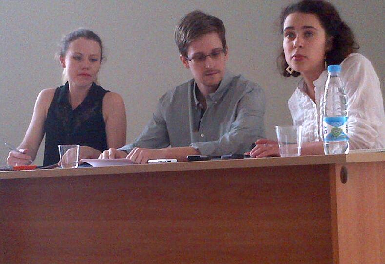 Der US-Geheimdienstenthüller Edward Snowden (M) spricht am 12.07.2013 mit Tanja Lokschina (r) von Human Rights Watch im Moskauer Flughafen Scheremetjewo.