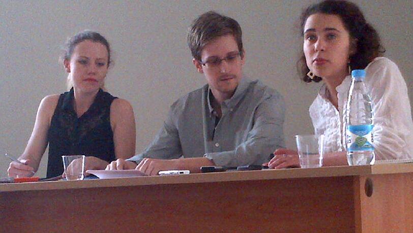 Der US-Geheimdienstenthüller Edward Snowden (M) spricht am 12.07.2013 mit Tanja Lokschina (r) von Human Rights Watch im Moskauer Flughafen Scheremetjewo. Der US-Geheimdienstenthüller Edward Snowden (M) spricht am 12.07.2013 mit Tanja Lokschina (r) von Human Rights Watch im Moskauer Flughafen Scheremetjewo.