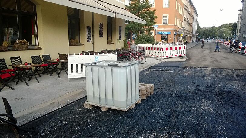 Dieses Foto ist im Sommer 2013 entstanden: Sperrgitter, ein Plastikfass und frischer Asphalt - nicht gerade das Ambiente, in dem man gerne zu Abend isst oder einen Cocktail schlürft.