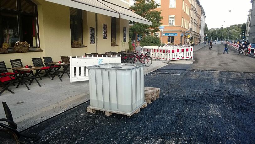 Dieses Foto ist im Sommer 2013 entstanden: Sperrgitter, ein Plastikfass und frischer Asphalt - nicht gerade das Ambiente, in dem man gerne zu Abend isst oder einen Cocktail schlürft. Dieses Foto ist im Sommer 2013 entstanden: Sperrgitter, ein Plastikfass und frischer Asphalt - nicht gerade das Ambiente, in dem man gerne zu Abend isst oder einen Cocktail schlürft.