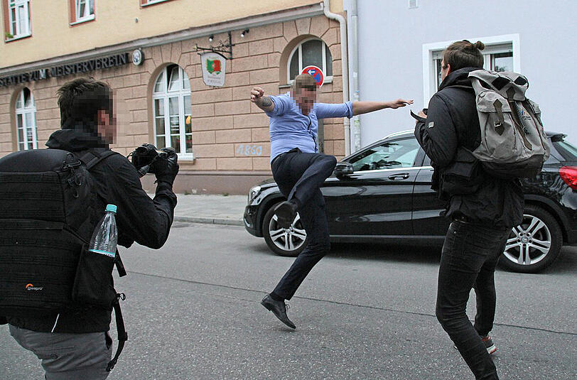 Der Mann trat nach den Fotografen.