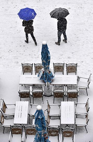 Dieses Straßencafé auf dem Marienplatz hat die Tische und Stühle trotz Wintereinbruchs draußen stehen lassen.