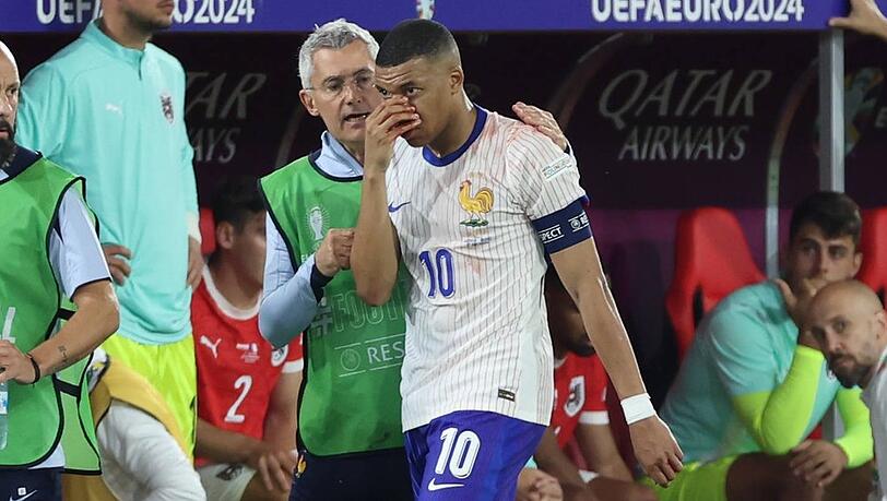 Kylian Mbapp&eacute; h&auml;lt sich beim Spiel gegen &Ouml;sterreich die Hand vor seine blutende Nase.