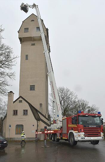 Einsatz in luftiger Höhe: Einsatzkräfte der Berufsfeuerwehr befestigen das gelöste Teil des Bechdaches.