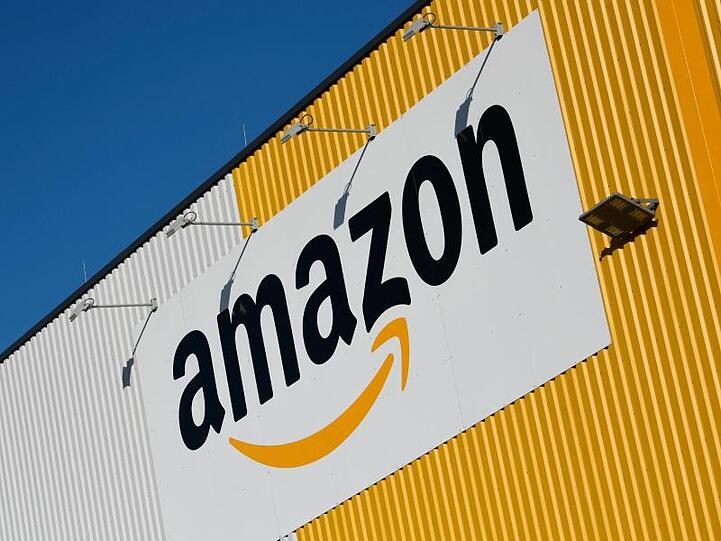 Das Logo von Amazon an einem Amazon-Logistikzentrum. Foto: Ina Fassbender/dpa/Archivbild